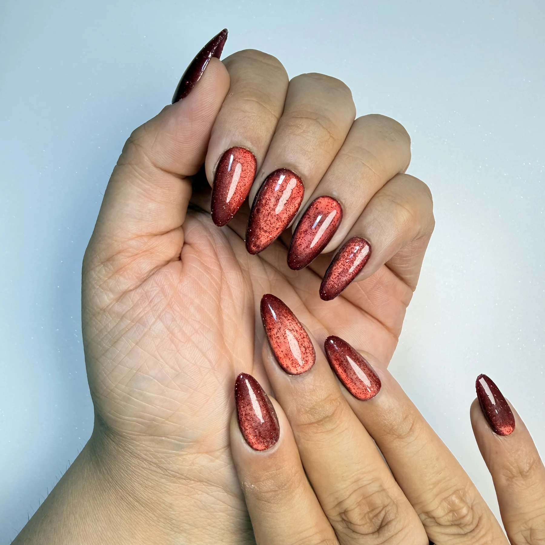 Red Cat Eye reflective glitter press-on nails with multidimensional molten shimmer